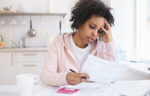 A former student looking at her bank statements. She is a part of the student debt crisis.