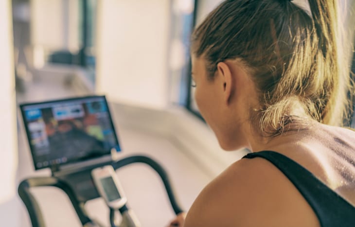 Woman uses Peloton stationary bike.