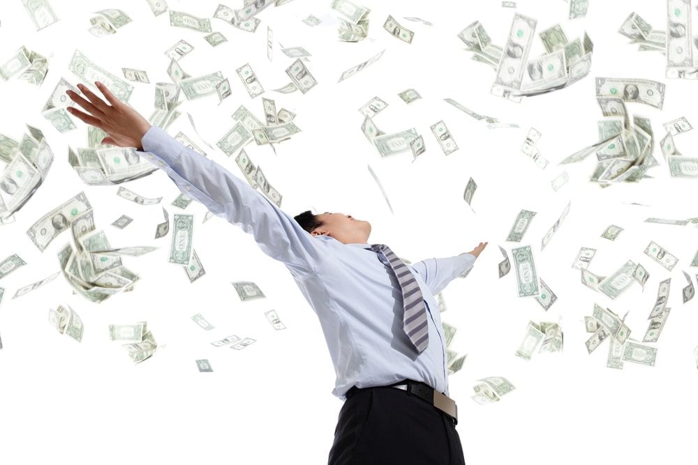 It's raining cash down on a man in business dress | Investment U