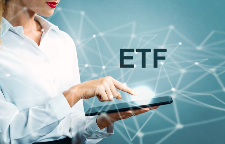 Touching a tablet searching how to invest in an ETF