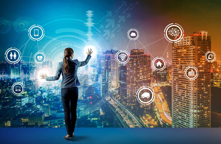 A business woman overlooking the city at a touchscreen connected to the Internet of Things (IoT) | Investment U