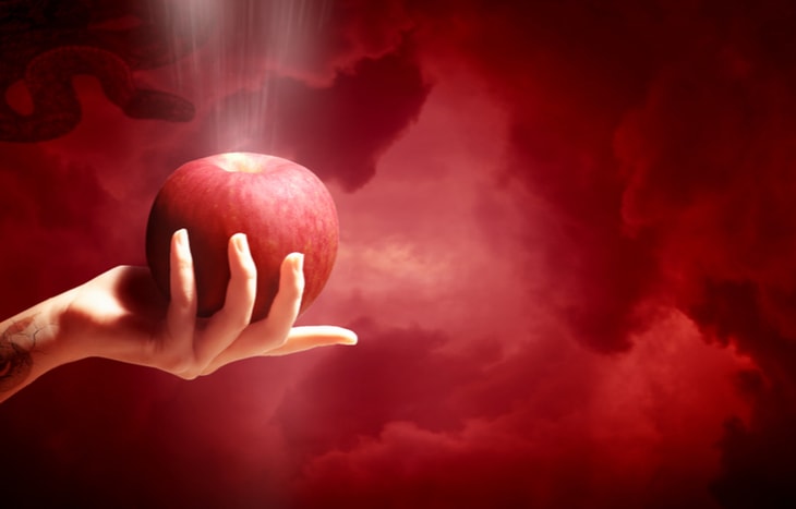 A woman’s hand holding a red apple against a smokey red backdrop. Is she enticing you to invest in sin stocks?