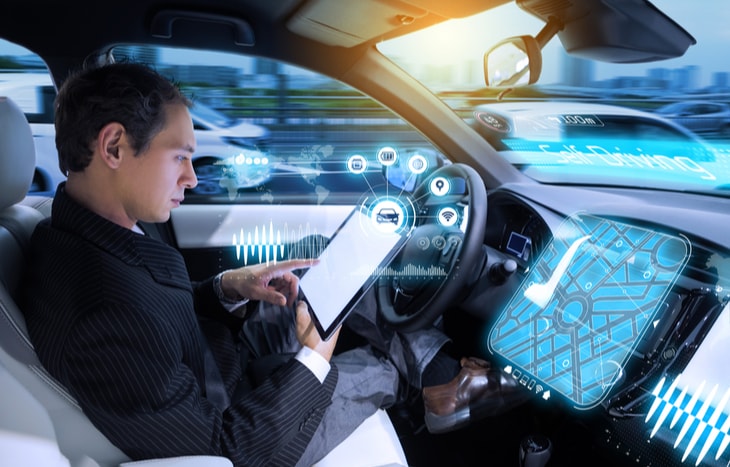 A man reading while sitting in a self-driving car