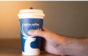 A hand holding a cup of Luckin' coffee. But will investors of Luckin Coffee stock be left holding the bag?