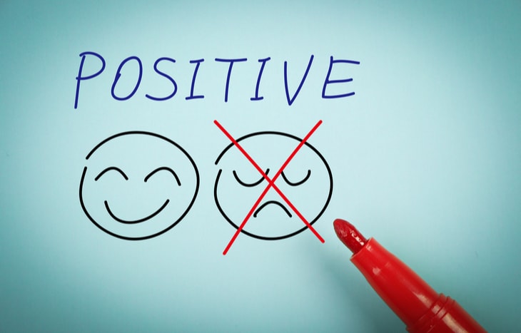 The word positive. A smiley face and a frown but the frown is crossed out with a red pen.