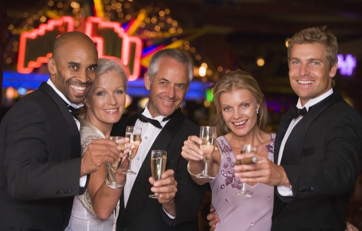 Five wealthy people dressed up nicely and drinking - wealth creation