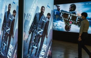 A movie goer walks by posters from Tenet, which has seemingly failed to save AMC stock in the short term.