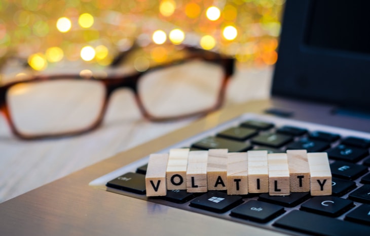 The word "volatility" spelled out in blocks on top of a laptop computer. Volatility trading is a type of stock trading.