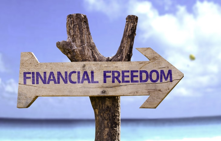 A sign on a beach that reads Financial Freedom pointing towards the goals of the FIRE movement.