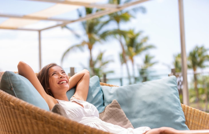 A woman who learned how to save for early retirement lounging in her backyard patio.