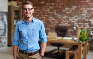 A young man by himself in an office - he saves his money for retirement in a solo 401(k)