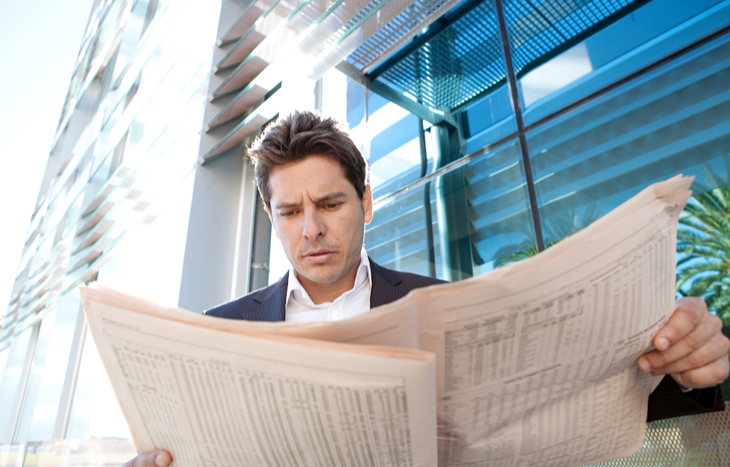 A man who enjoys active trading reading the paper